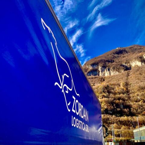 Dettaglio semirimorchio Zordan Logistica con logo, sullo sfondo paesaggio montano