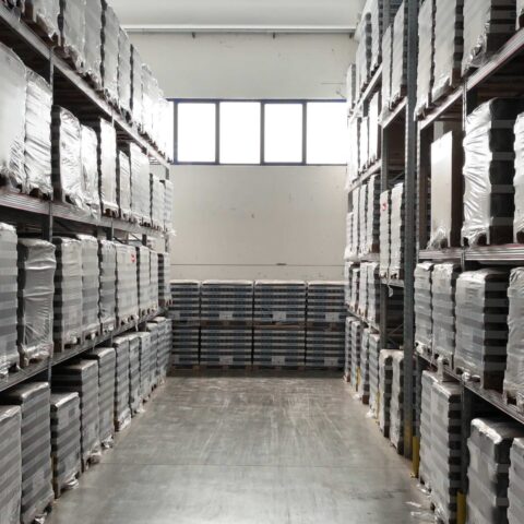 Corsia di magazzino Zordan Logistica con pallet ordinati e scaffalature alte per lo stoccaggio merci.