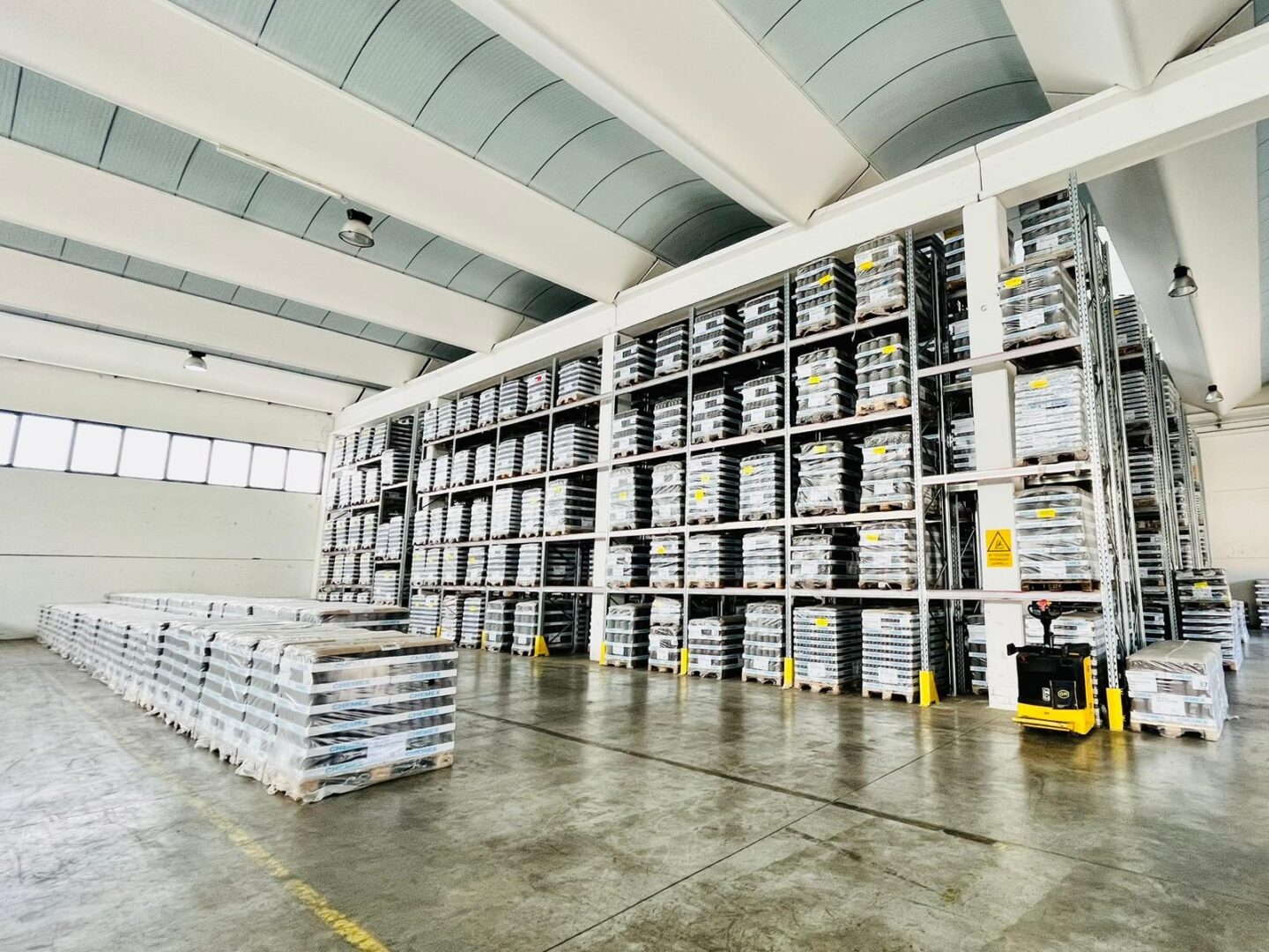 News e approfondimenti | Immagine del magazzino industriale con scaffalature alte piene di pallet e merce stoccata